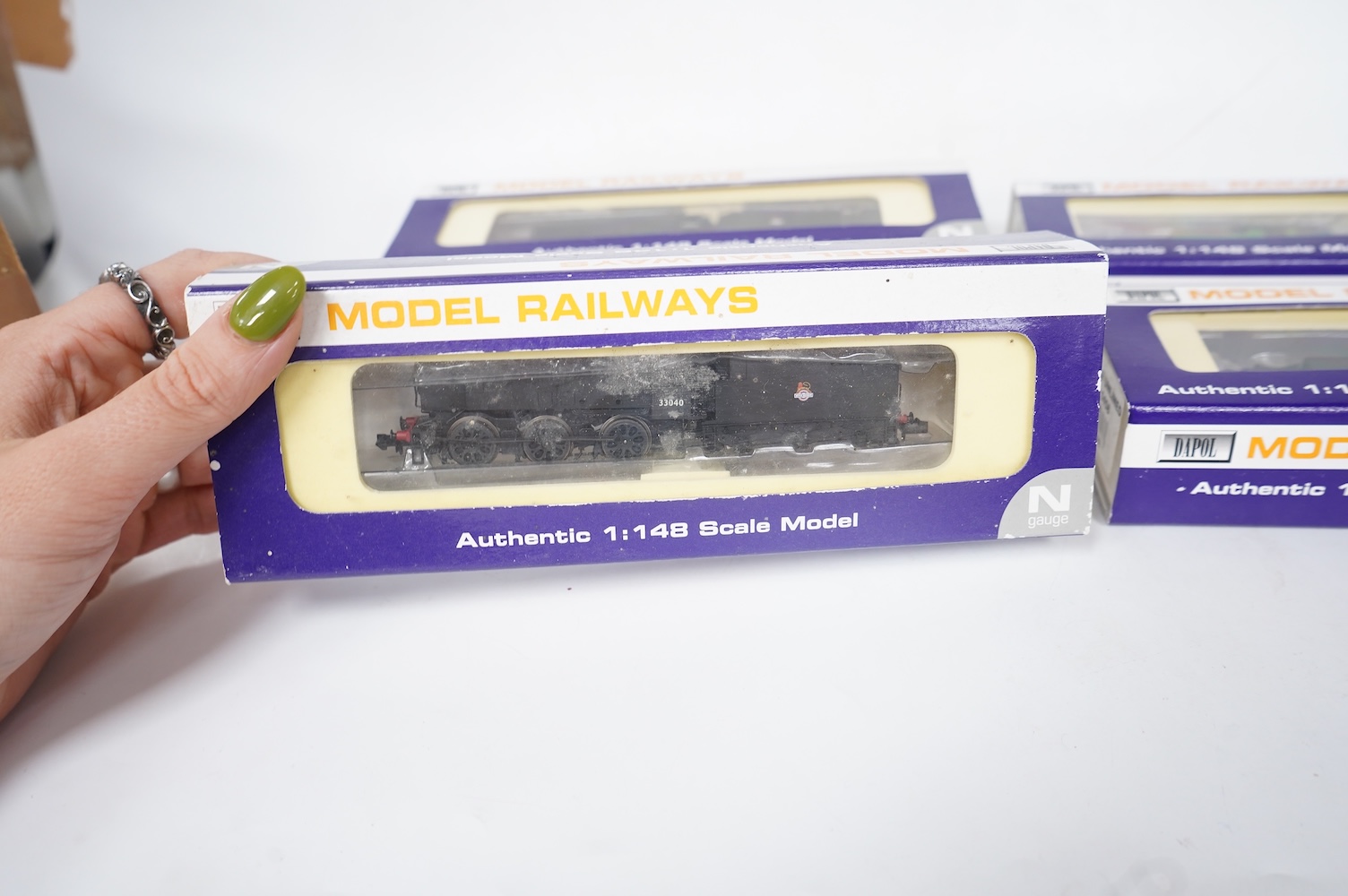 Four boxed Dapol N gauge railway locomotives; two BR Class Q1, both 33040 (ND-076B), one in associated box, a BR Class 14xx, 1458 (ND002) and an SR Class M7, 676 (ND-046). Condition - good.